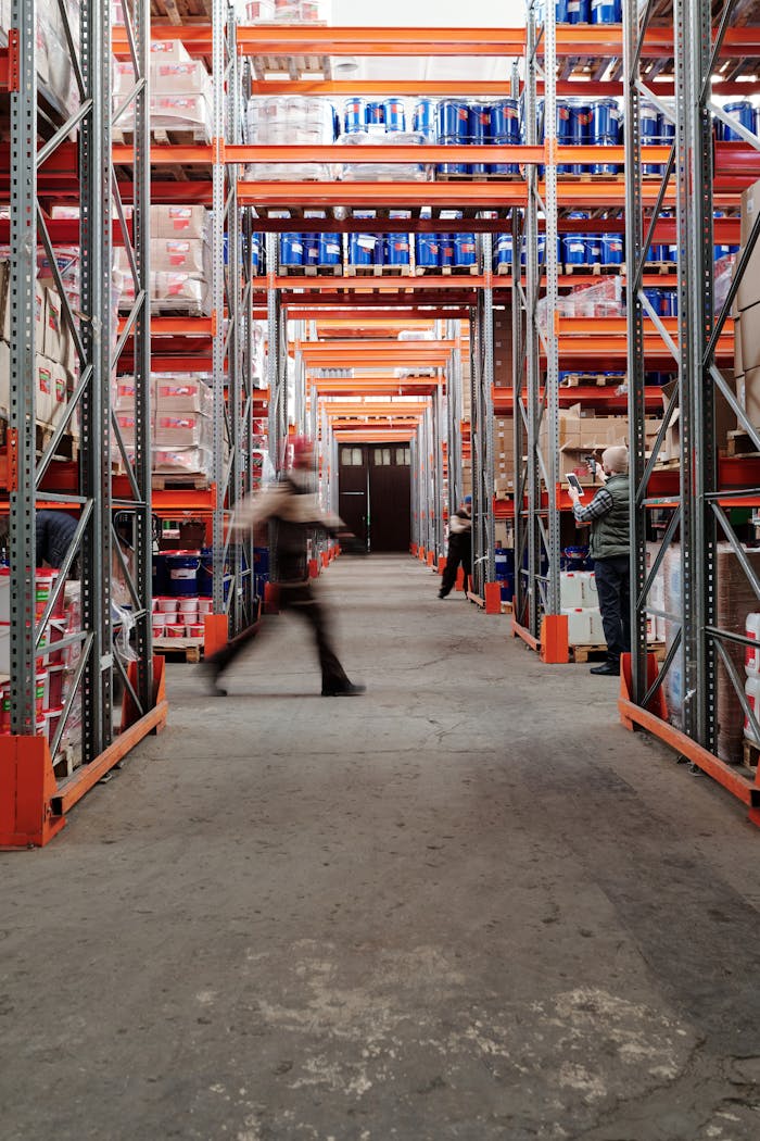 Industrial warehouse with shelves and a moving worker, showcasing organized storage.