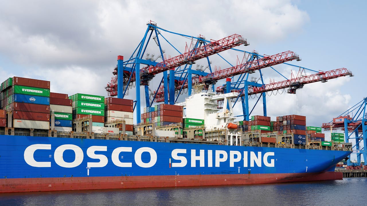 Container ship COSCO at Hamburg port with cranes handling cargo.